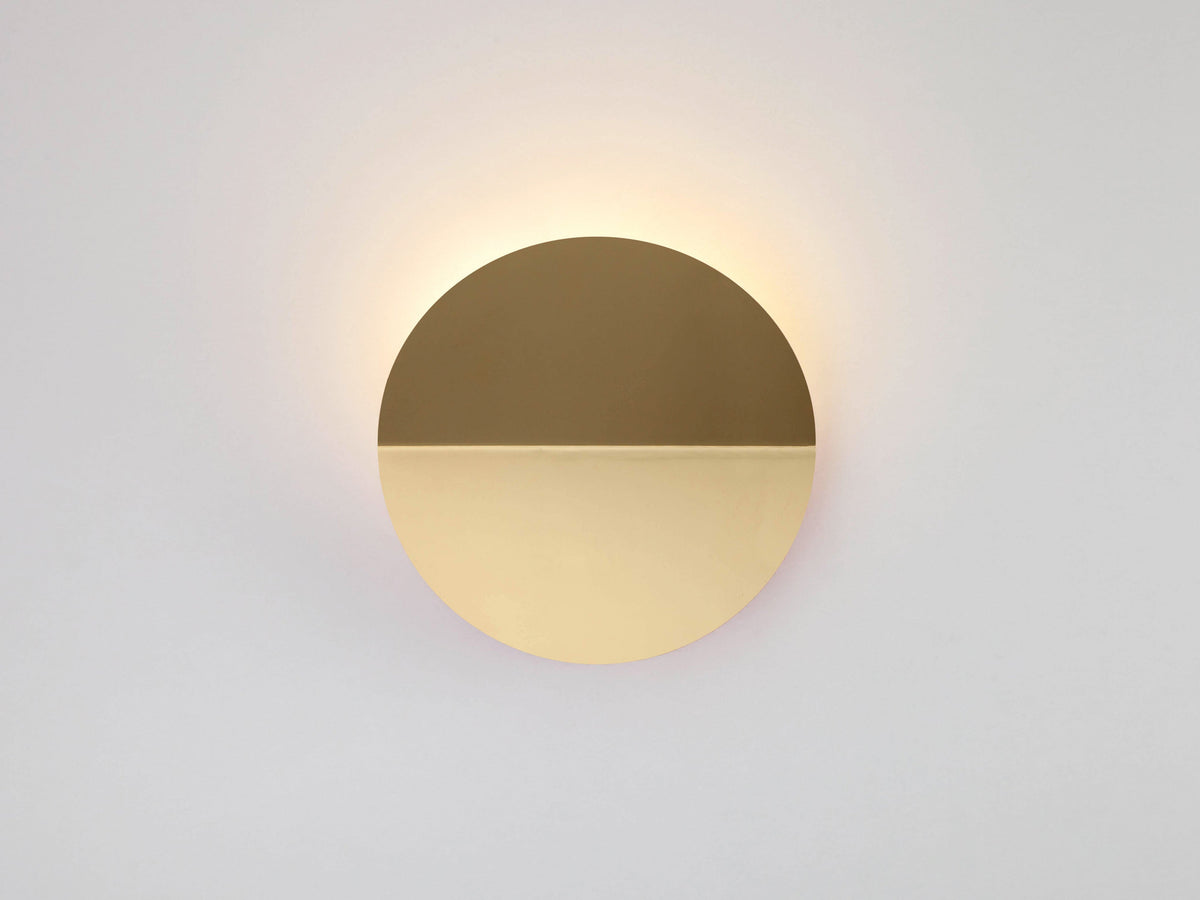 Brass diffuser wall light casting a warm glow